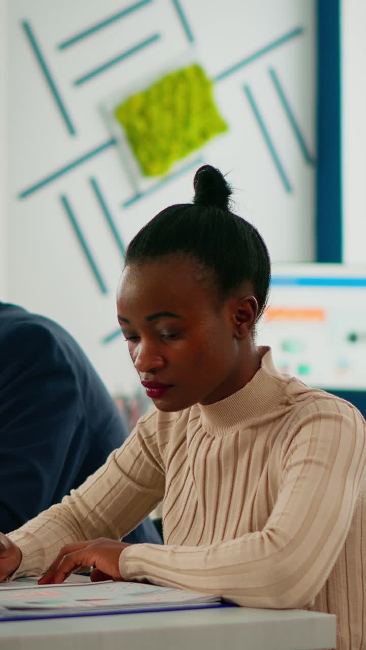 Vertical video African businesswoman analysing report and looking at camera smiling