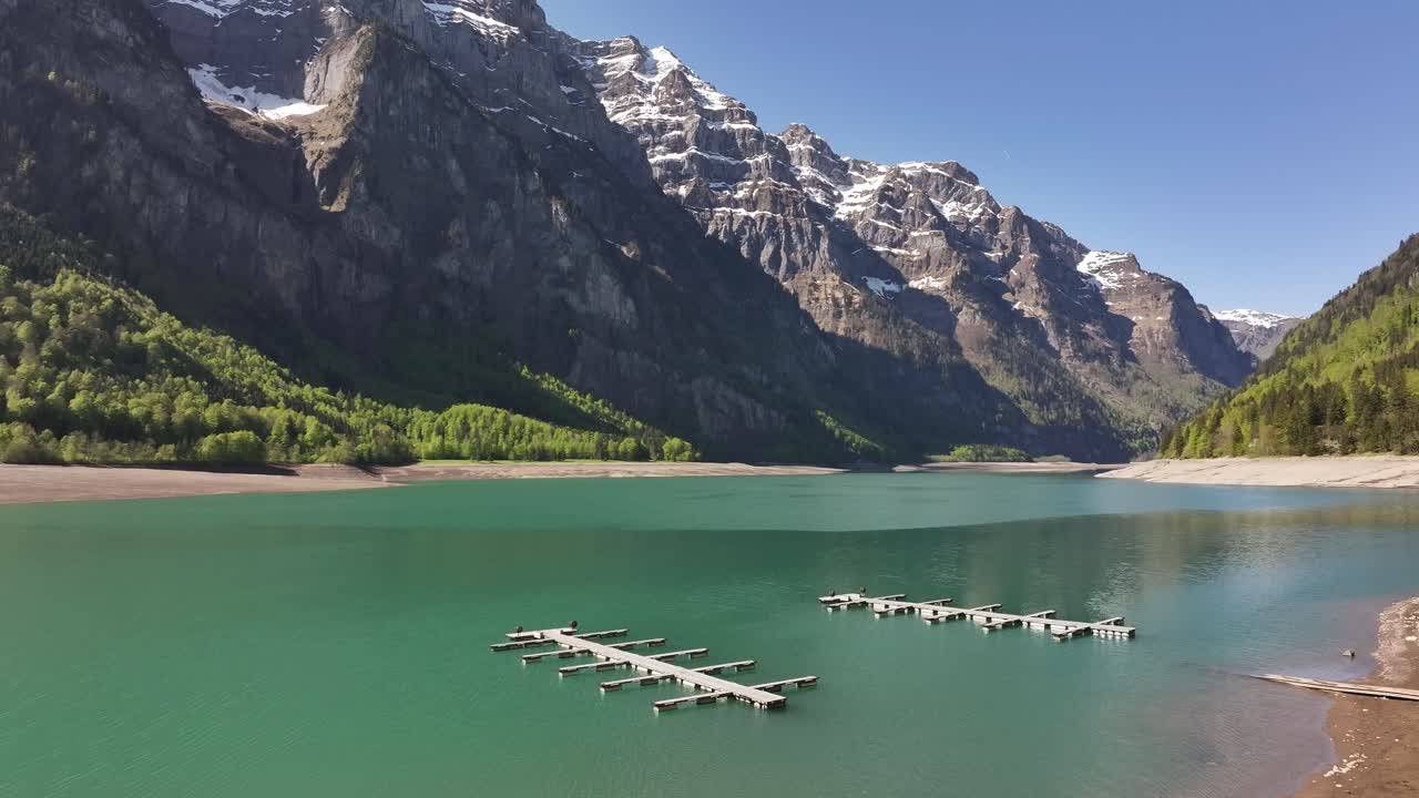 Klöntalersee lake beautiful aerial drone view surrounded by snow mountains and green forest in Glarus, Switzerland