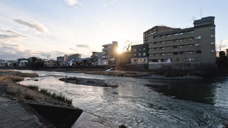 time-lapse of a river flowing through a city at sunset.