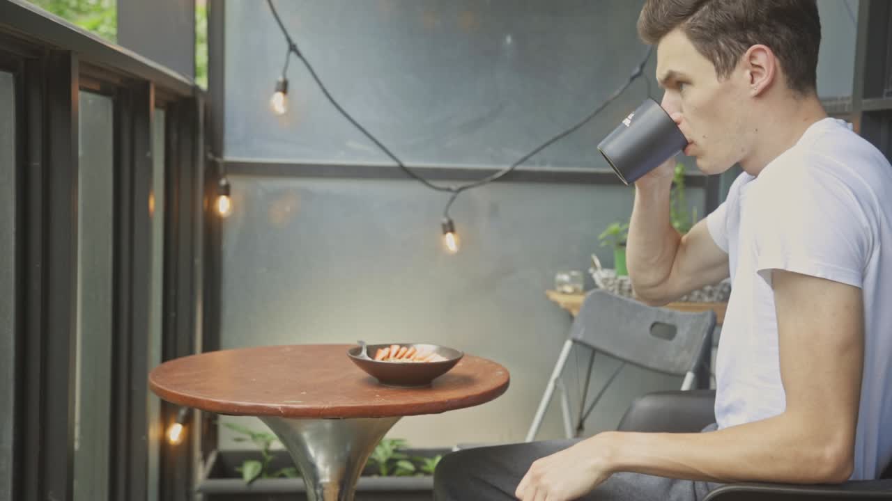 retrato de un hombre caucásico comiendo un desayuno saludable en el pequeño patio