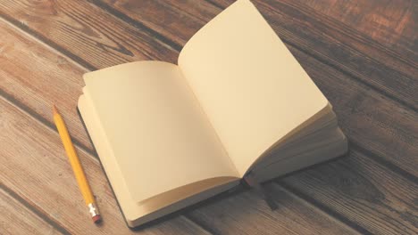 open notebook and pencil on wooden table