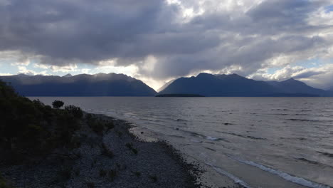 Luftaufnahme-Der-Sonnenstrahlen,-Die-Aus-Den-Wolken-über-Dem-Atemberaubenden-Blauen-See-In-Neuseeland-Hervorlugen