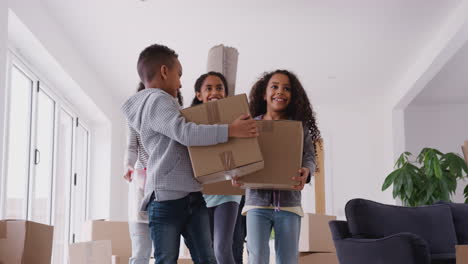 smiling family carrying boxes into new home on moving day