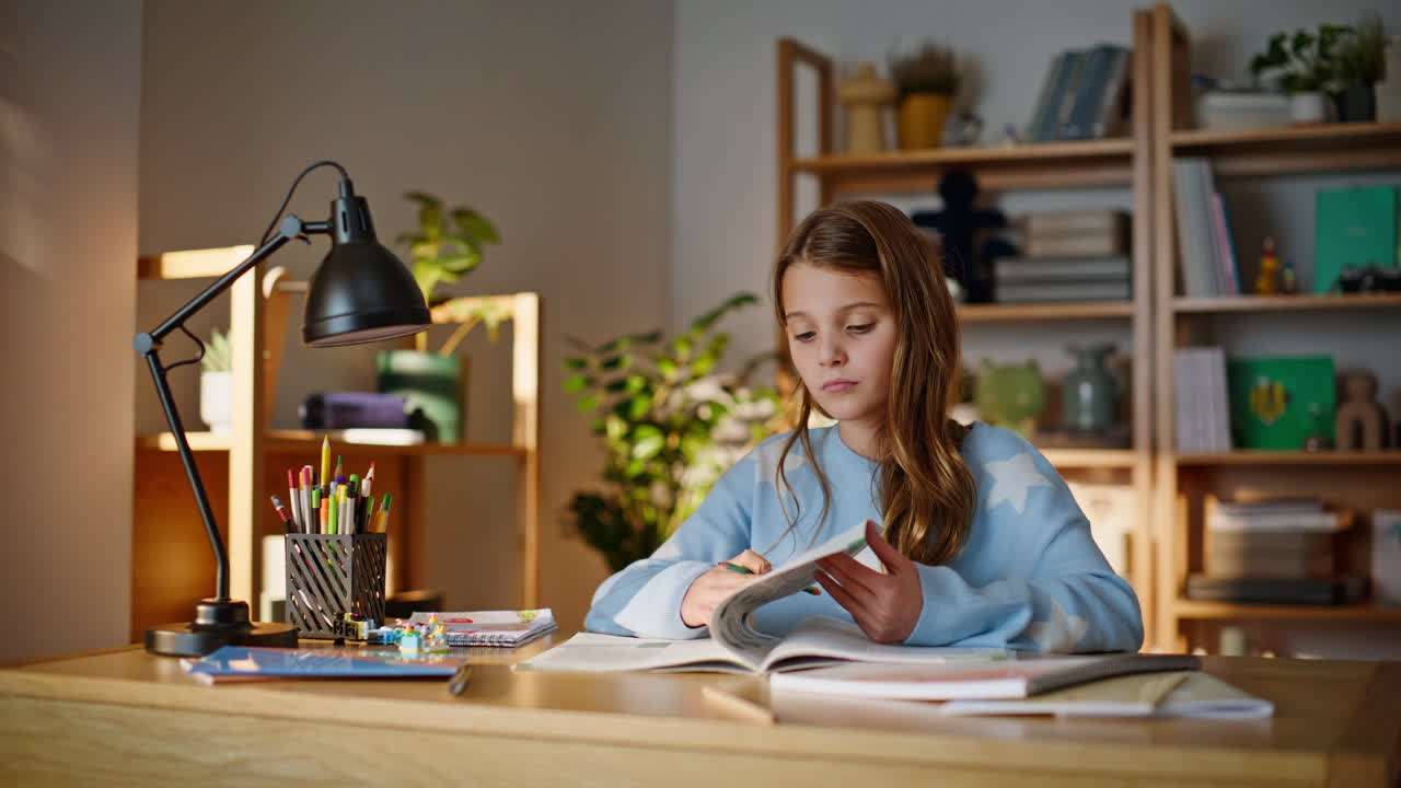 Clever schoolgirl writing notebook making homework home workplace closeup