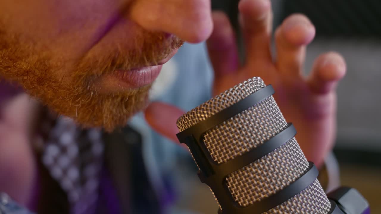 Close-up of a man speaking into a professional dynamic microphone in a podcast or recording studio. Guy podcasting or broadcasting, voiceover work, streaming, radio, and ASMR content creation