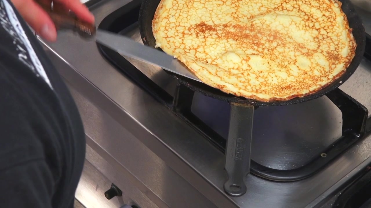 SLOMO: Ripresa di un cuoco che prepara pancake su un fornello