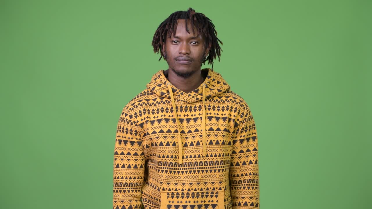 Giovane uomo africano bello con il dito sulle labbra