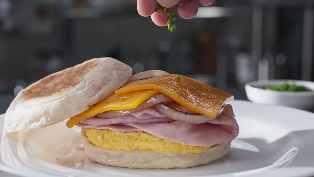 Condire un panino con cipollotti tritati, al rallentatore, con zoom avanti