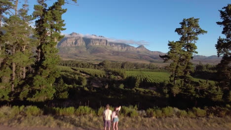 vuelo a través de la toma de una pareja joven de pie en el paisaje rural