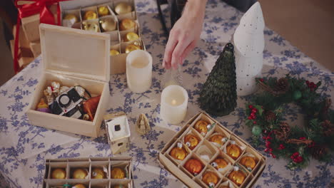 friends taking christmas ornaments from table