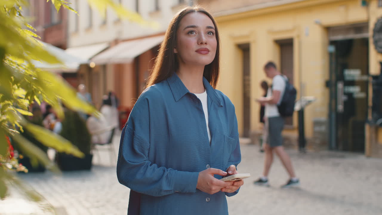 feliz mujer joven sonriendo mirando lejos soñando descansando buenas noticias sentirse satisfecho en la calle de la ciudad