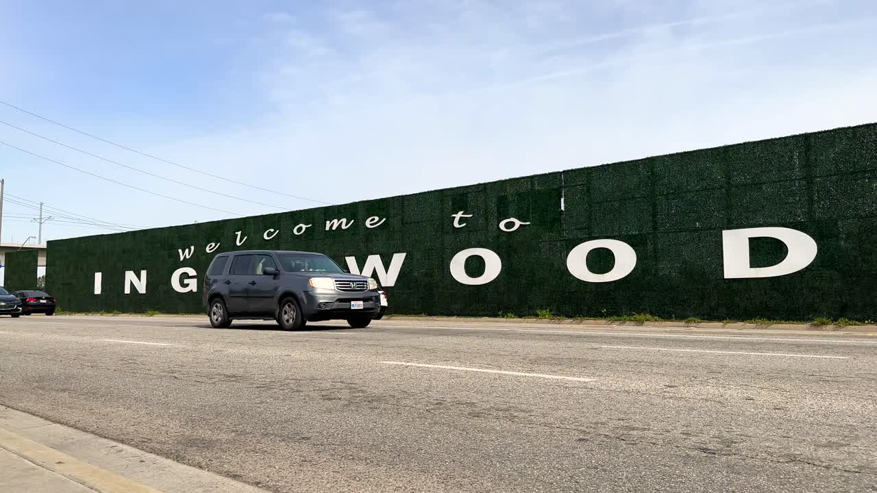 дорожный знак "добро пожаловать в инглвуд, калифорния", проезжающие автомобили в пасмурный день