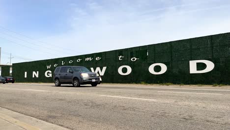 bienvenido a la señal de tráfico de inglewood california mientras los autos pasan en un día nublado