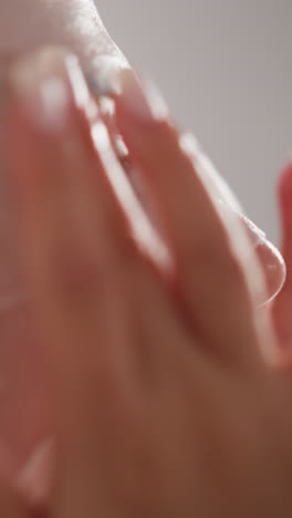 dama suaviza la máscara de tela hidratante con las puntas de los dedos. mujer en bata de baño golpea la máscara facial con los dedos después de lavarse en el baño en cámara lenta