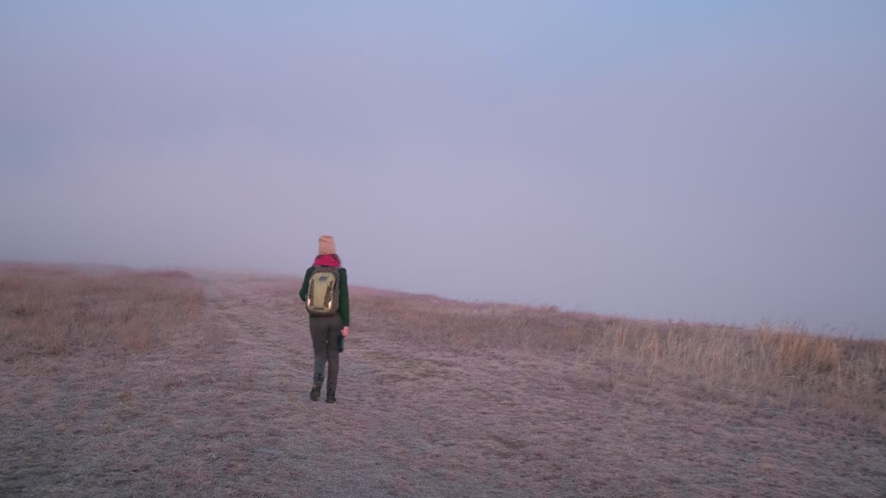 해가 뜨면 안개가 가득한 산에서 산책하는 여자