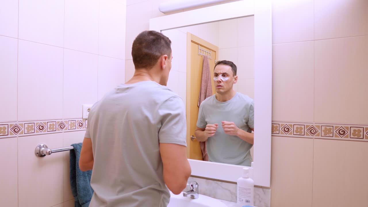 Man removing anti dark circles patches in bathroom