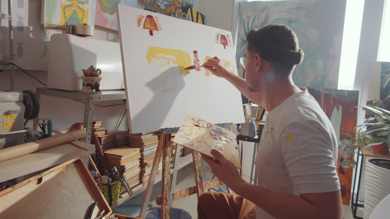 Artist Painting Picture with Palette Knife in Studio