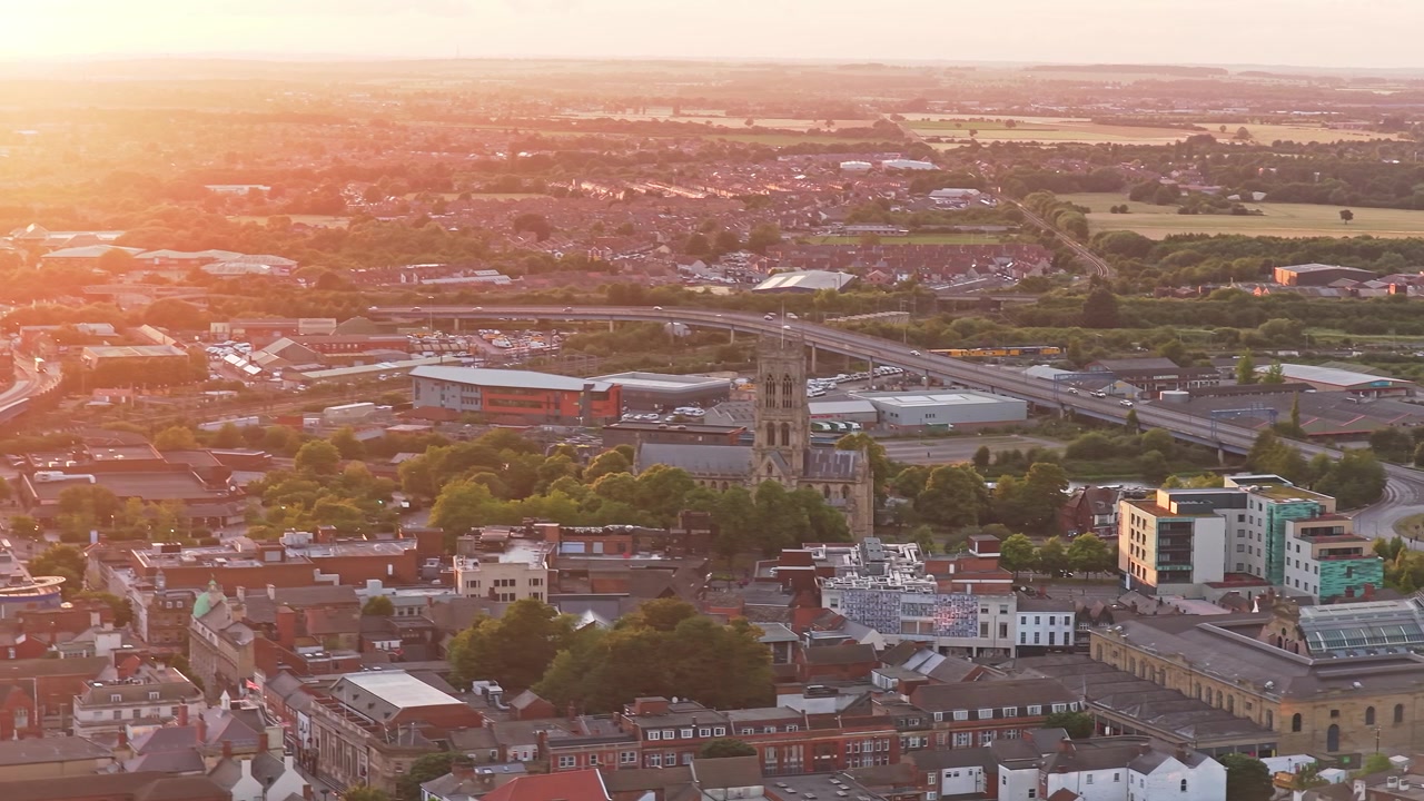 Doncaster Minster menjulang di samping Jembatan St George dan Jalan St George A19 di Doncaster, South Yorkshire, Inggris, Britania Raya, dikelilingi oleh inti kota bersejarah, geseran lateral drone