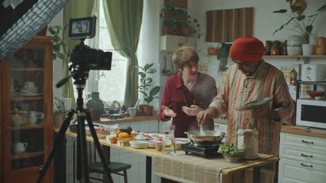 indian chef and cooking show host filming food vlog in kitchen