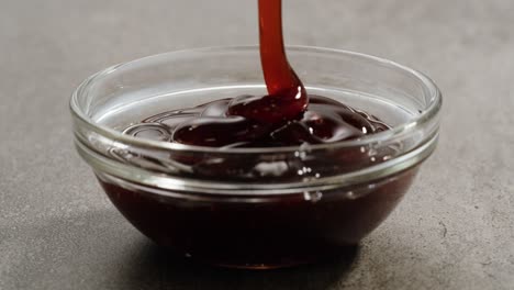 pouring brown sauce into glass bowl