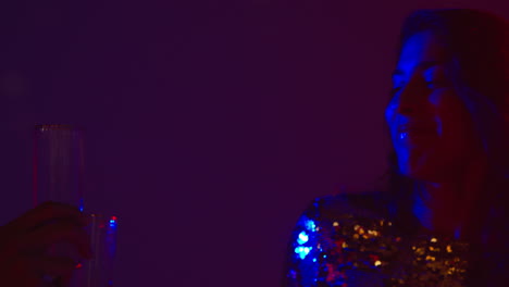 cerca de dos mujeres en un bar de club nocturno o discoteca bailando y bebiendo alcohol