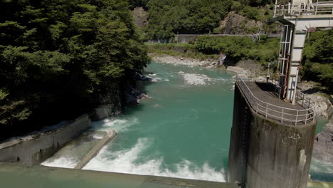 aerial looking down into small dam and blue-green water in kochi prefecture on the island of shikoku, japan