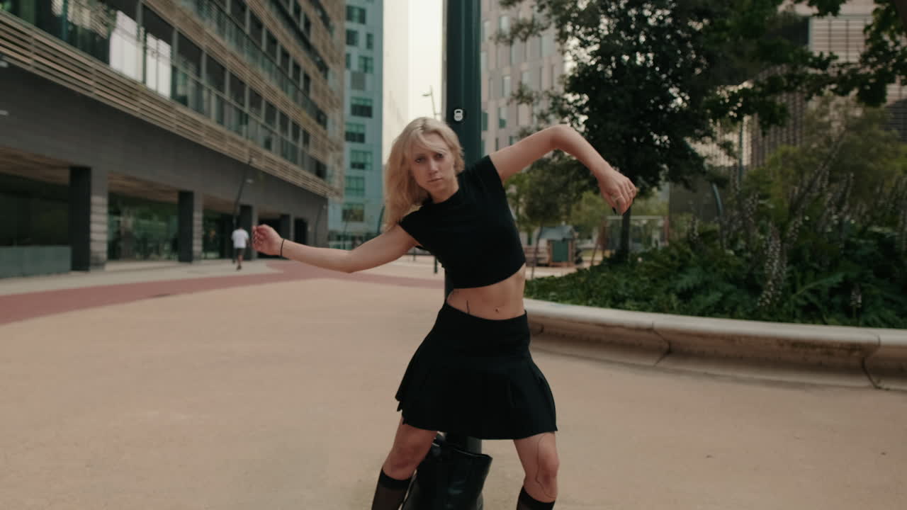都会で感情豊かに踊る若い金髪の女性