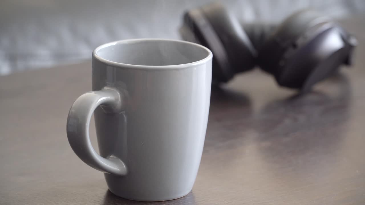 relazation을 위한 헤드폰으로 김이 나는 커피 또는 차