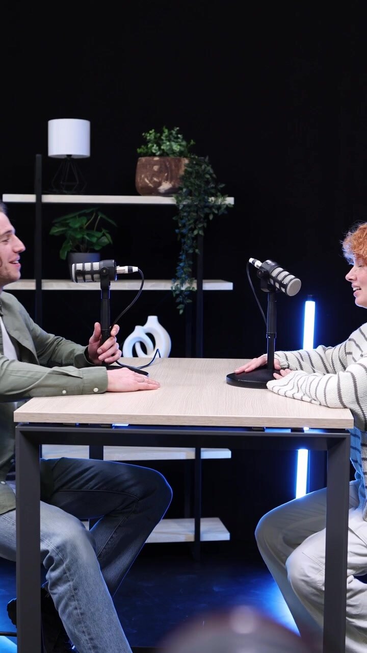 Man and Woman Setting Up for a Podcast Interview in a Modern Studio