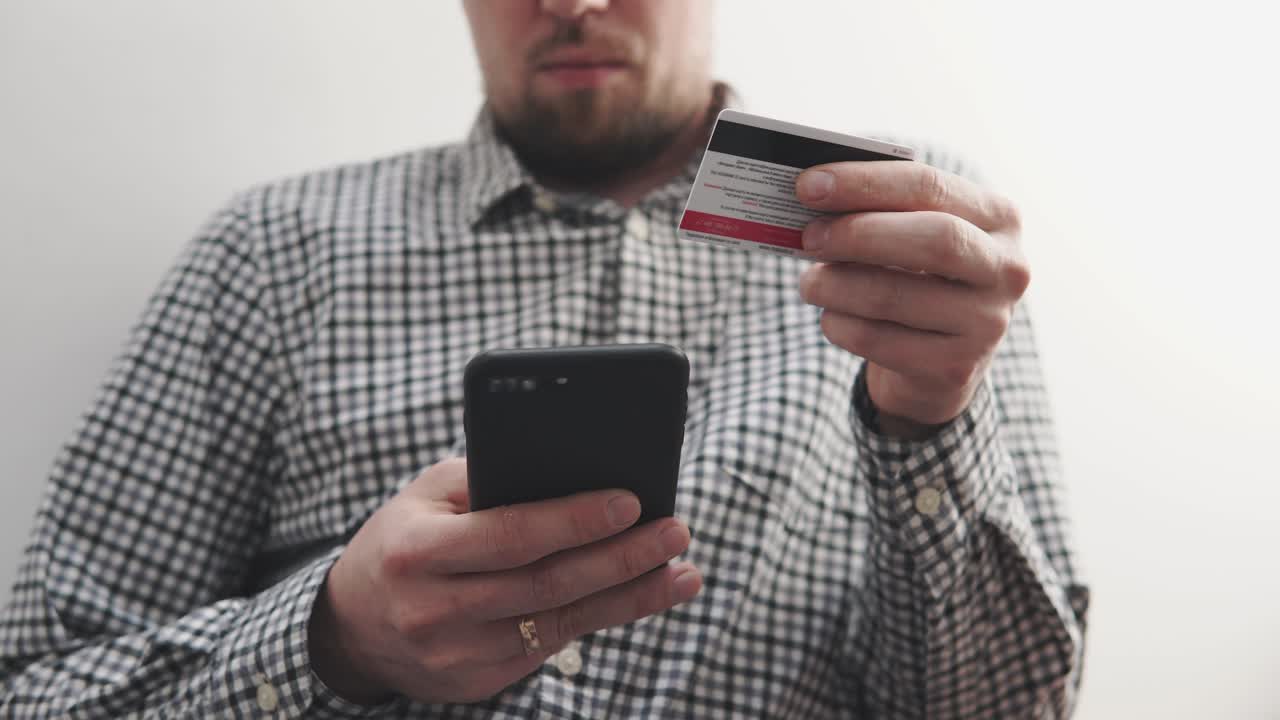 hombre usando teléfono inteligente y tarjeta de crédito para el pago móvil
