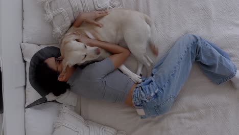 top-down shot of a woman hugging, kissing, and cuddling with her cute labrador puppy at home. a heartwarming moment of animal love, pet bonding, and puppy affection in a cozy home. dog best friend.