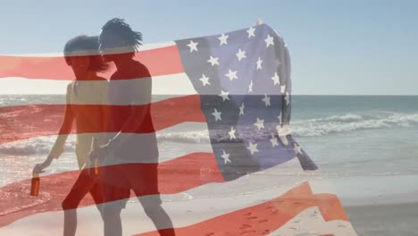 Animation-of-American-flag-waving-over-mixed-race-couple-by-seaside-on-summer