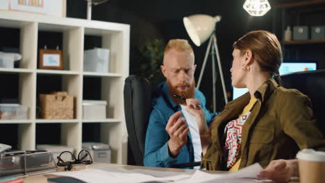 Business-people-working-documents-in-late-office.-Hipster-couple-talking-indoors