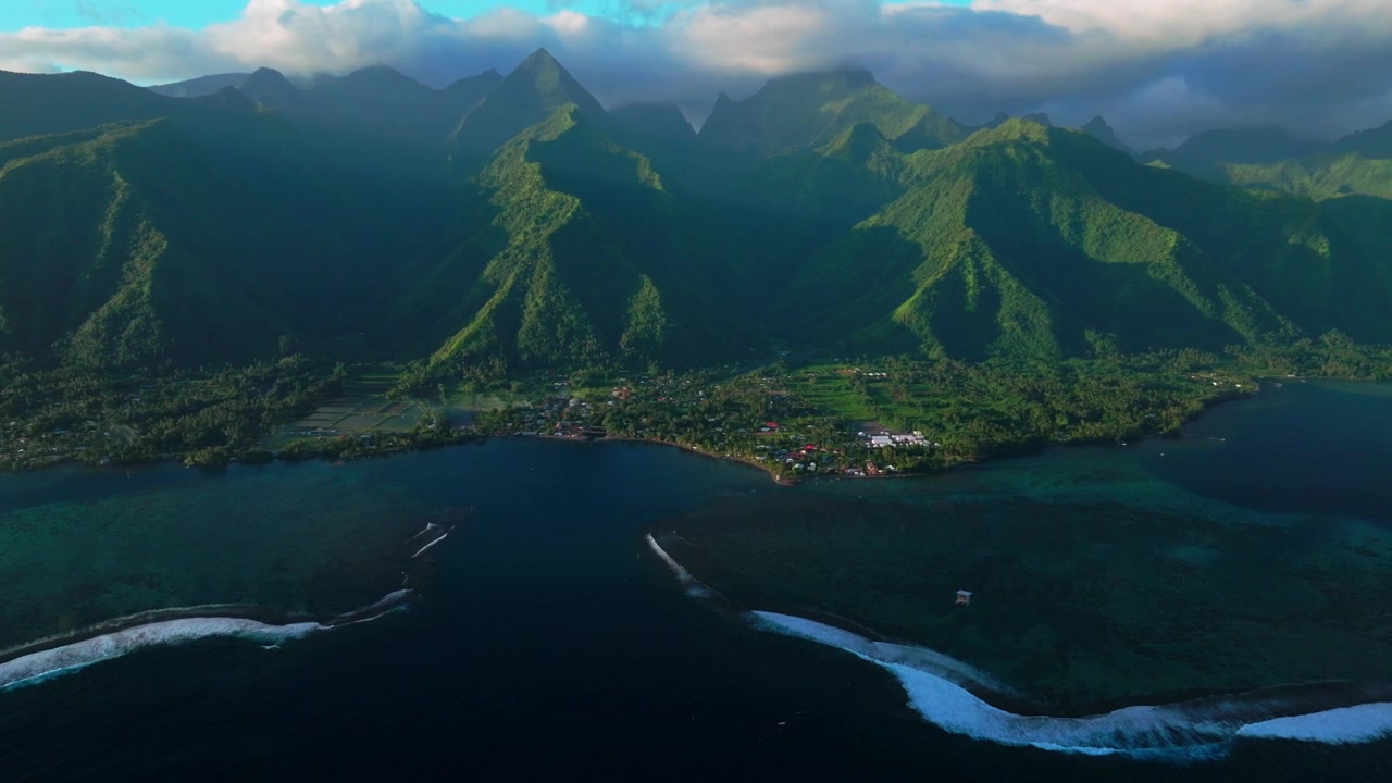 Tahiti landscape aerial drone French Polynesia Teahupo'o surf wave lagoon Passe Havea coral reef harbor view South Pacific Ocean island golden light rays volcano peaks beach coastline forward pan up