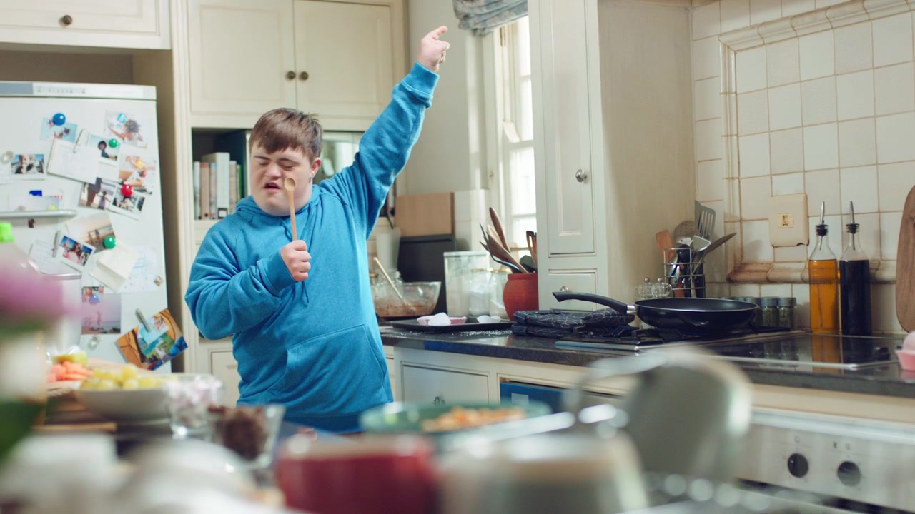 Young Man With Down Syndrome Dancing and Singing in Kitchen