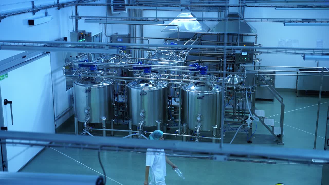 Top view on the modern milk factory indoors. Contemporary equipment for making cheese inside the dairy manufacturing plant.