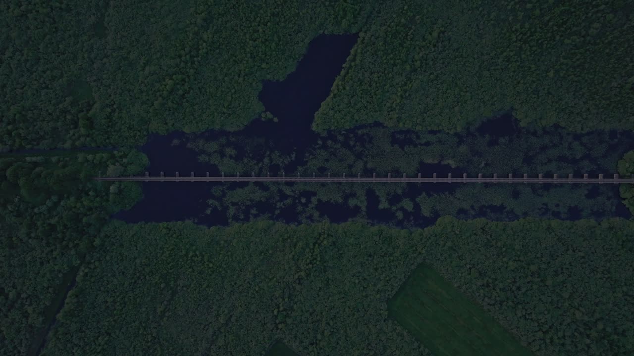 Vista aerea di Moerputtenbrug con treno, tramonto, persone a passeggio, che mostra un paesaggio storico drammatico nei Paesi Bassi.
