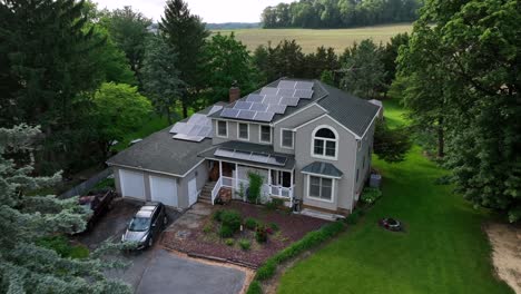 two-story single family house with solar panels on roof. cloudy day in american suburb. car on street of rural district. aerial approaching shot.