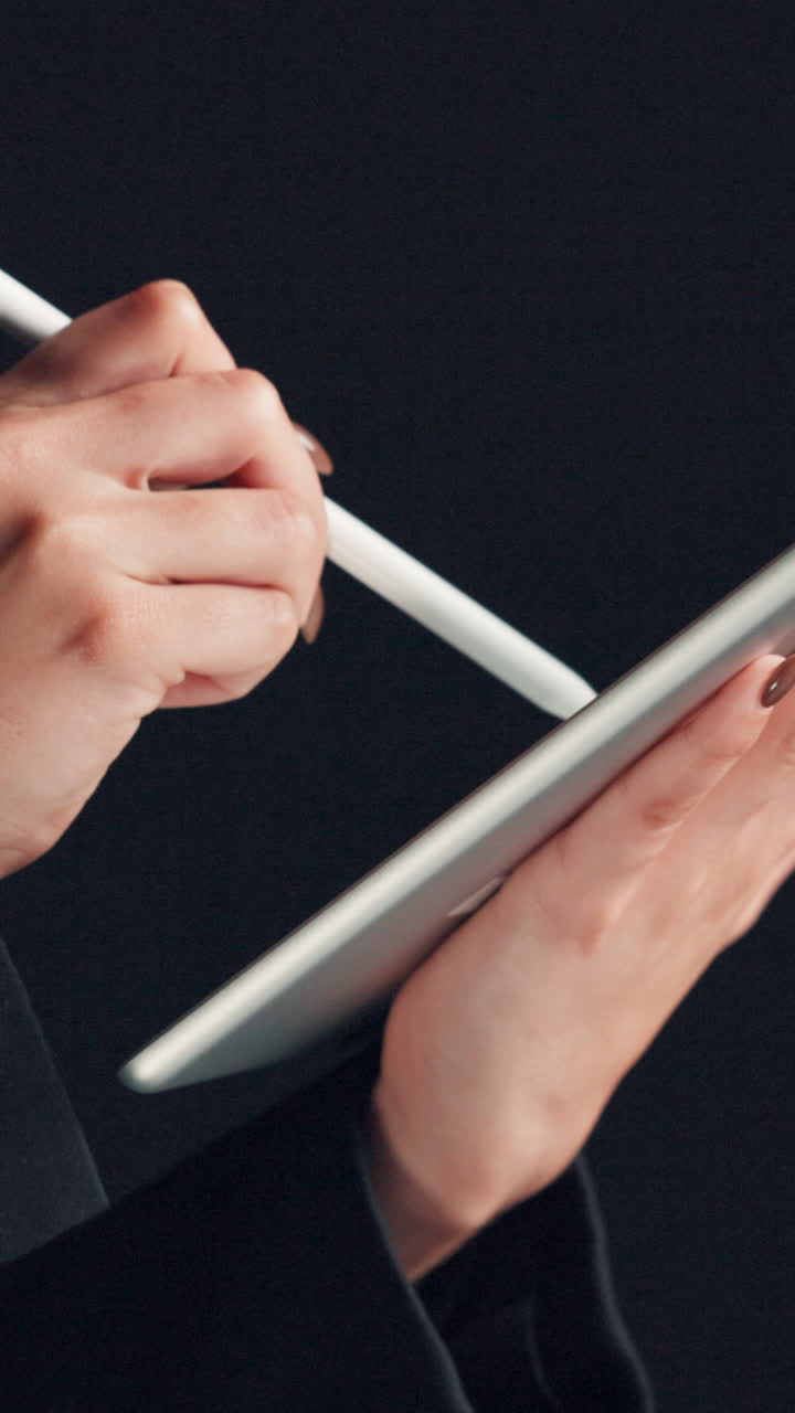 Primo piano di una mano che usa uno stilo per disegnare su un tablet digitale