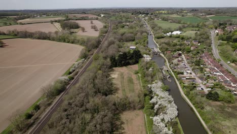 Hatton-Locks-Narrow-Boat-In-Canal-And-Train-On-Railway-Line-Spring-Season-Aerial-View-Grand-Union-London-Northwestern