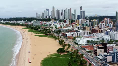 tilting up dolly out aerial drone shot of the cityscape of the colorful tropical beach capital city of joao pessoa in paraiba, brazil from the tambaú neighborhood on an overcast morning