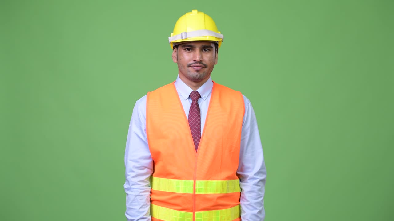 Young handsome Persian man construction worker shrugging shoulders