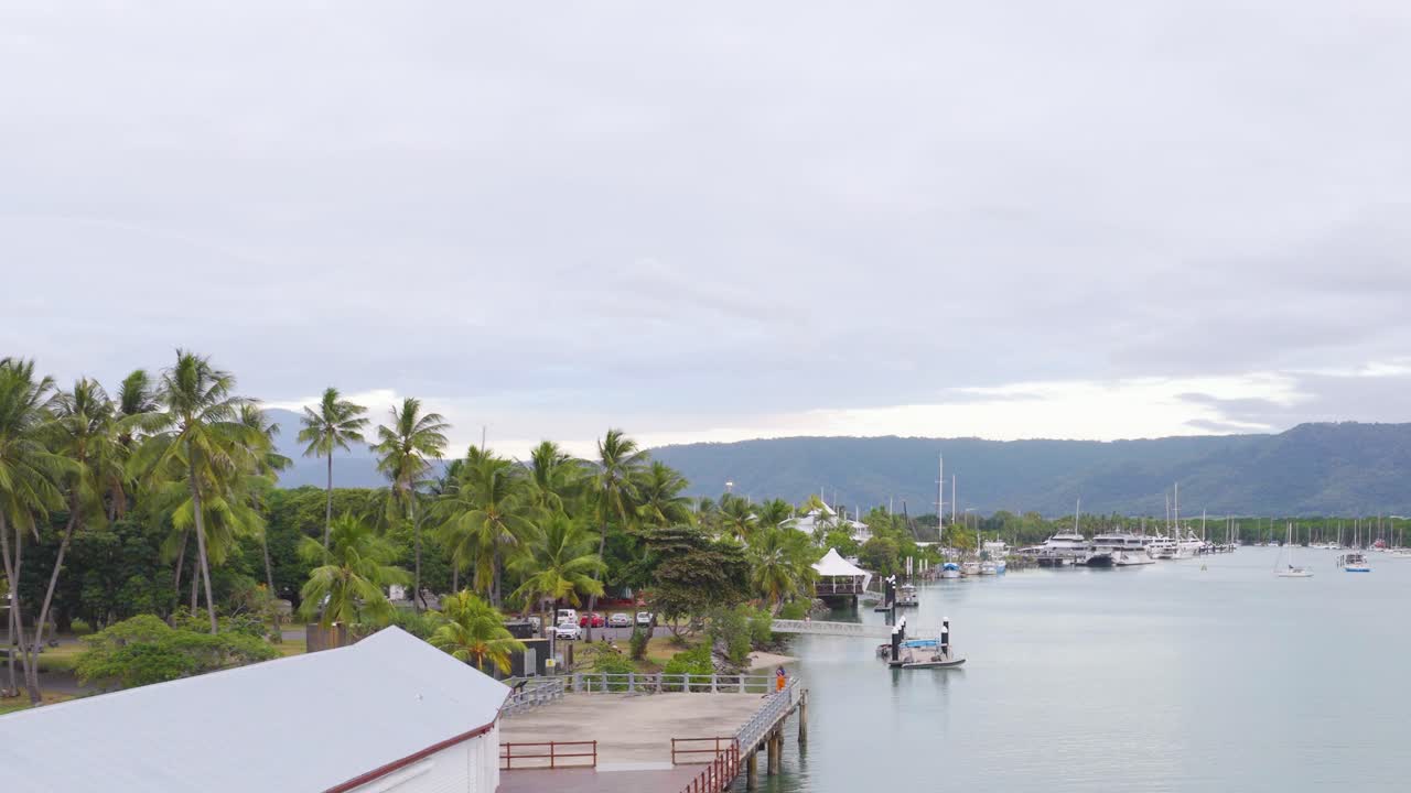 A serene river scene with lush greenery and calm waters under overcast skies in Port Douglas, Queensland