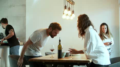 Cheerful-young-people-talking-and-sitting-at-table