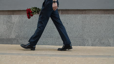 businessman going on date outdoor. man carrying flowers at stree