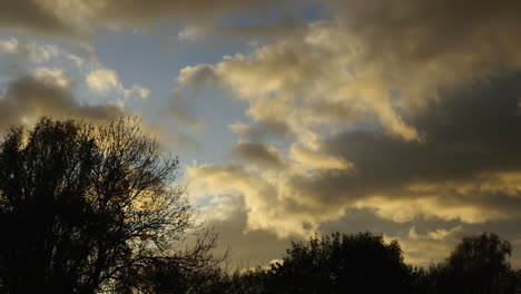 la luz del sol de la tarde ilumina las nubes de tormenta mientras se reúnen sobre worcestershire, inglaterra al anochecer en un time-lapse en un día de viento