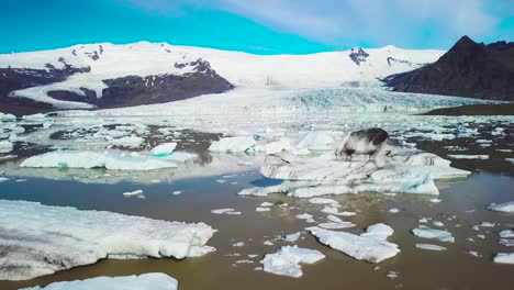 slow aerial across the massive glacier lagoon filled with icebergs at fjallsarlon iceland suggests global warming and climate change 3