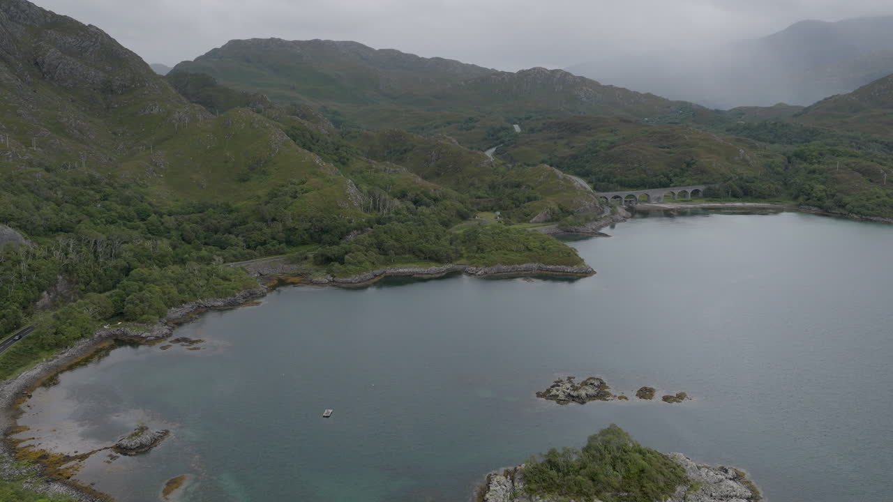 레이크 난 우암 (loch nan uamh) 은 철도 다이아트 (railway viaduct) 를 향해 물 위에서 동쪽으로 향하는 공중 촬영입니다.