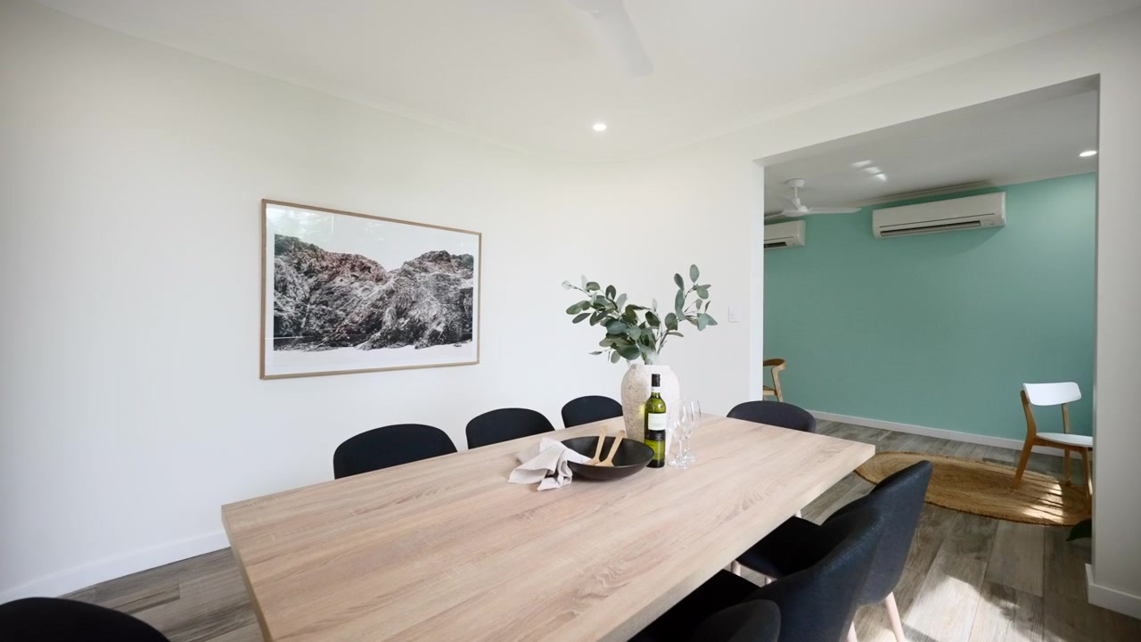 Pequeña área de comedor en pasillo en una hermosa casa de lujo moderna y minimalista, completa con suelos de madera, cuadros y paredes blancas y azules. Interior de casa para propiedad inmobiliaria