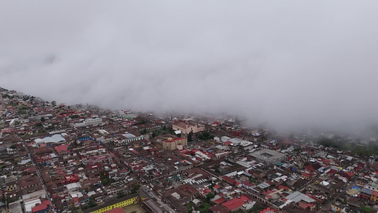 A stunning view of a large Mexican village, half obscured by drifting clouds. Zacatlan iconic climate